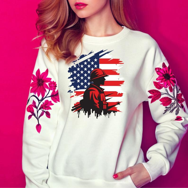 May include: White sweatshirt with a distressed American flag design and a silhouette of a soldier holding a rifle. The flag is red, white, and blue. The soldier is black. The sweatshirt has pink floral embroidery on the sleeves.