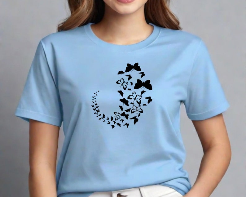 Puede incluir: Una camiseta azul claro con un dise&ntilde;o negro de un patr&oacute;n de mariposas en espiral.