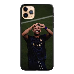 Op de afbeelding: Een zwarte telefoonhoes met een foto van een voetballer die een hartje maakt met zijn handen. De voetballer draagt een zwart shirt met het woord "KAFT" erop.