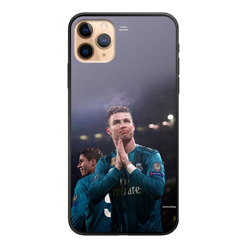 Op de afbeelding: Een zwarte telefoonhoes met een transparante achterkant met een foto van een voetballer in een blauw-wit shirt met de tekst "Fly Emirates" op de voorkant. De speler houdt zijn handen bij elkaar in een gebedspositie. De achtergrond is een wazige afbeelding van een stadion in de nacht.