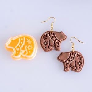 Scandi folk bear polymer clay cutter with matching brown mirrored earrings, highlighting clean and balanced imprint details