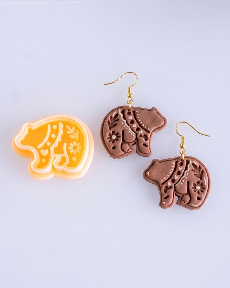 Scandi folk bear polymer clay cutter with matching brown mirrored earrings, highlighting clean and balanced imprint details