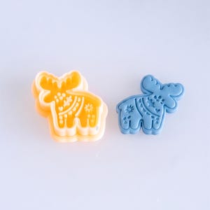 Scandi folk moose polymer clay cutter with finished clay piece in muted sky blue, highlighting clean imprint details