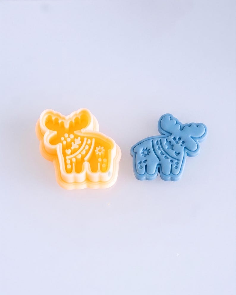 Scandi folk moose polymer clay cutter with finished clay piece in muted sky blue, highlighting clean imprint details