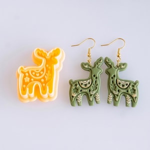 Scandi folk deer polymer clay cutter with mirrored earring pair in moss green, showing detailed imprint design