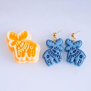 Scandi folk moose polymer clay cutter with matching blue mirrored earrings, showing crisp and bold imprint pattern