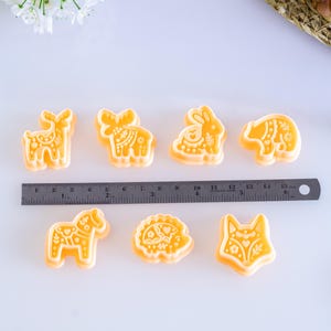 Scandi folk animal polymer clay cutters displayed with a metal ruler for size reference, showing multiple animal shapes and their approximate dimensions for jewelry making