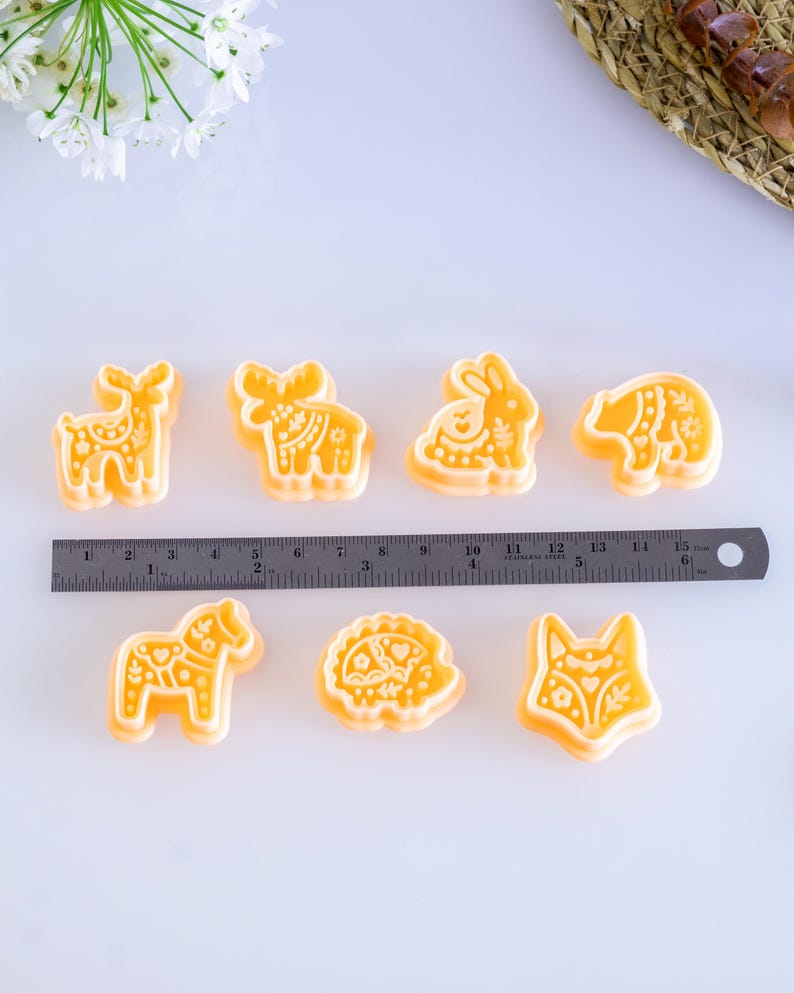 Scandi folk animal polymer clay cutters displayed with a metal ruler for size reference, showing multiple animal shapes and their approximate dimensions for jewelry making