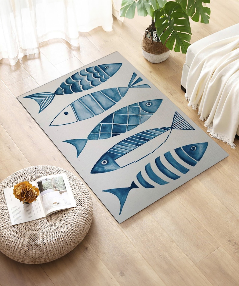 Puede incluir: Una alfombra azul y blanca con un dise&ntilde;o de acuarela de cinco peces. Los peces est&aacute;n dispuestos en forma escalonada y tienen diferentes dise&ntilde;os.