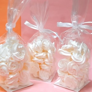 May include: Three clear plastic bags filled with white meringue cookies, tied with white ribbon.