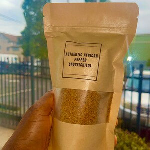 Peut inclure: Un sachet en papier brun avec une fen&ecirc;tre transparente montrant une poudre brune &agrave; l'int&eacute;rieur. Le sachet porte une &eacute;tiquette indiquant "AUTHENTIC AFRICAN PEPPER SAUCE(SHITO)"