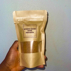 Peut inclure: Un sac en papier brun avec une fen&ecirc;tre transparente montrant une poudre brune &agrave; l'int&eacute;rieur. Le sac porte une &eacute;tiquette indiquant "AUTHENTIC AFRICAN PEPPER SAUCE(SHITO)"