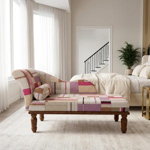 May include: A chaise lounge featuring a patterned fabric upholstery in shades of pink, purple, beige, and brown with a geometric block design. The furniture piece includes a matching cylindrical bolster pillow and rests on four dark wooden legs.