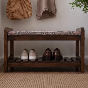 A wooden bench with a woven seat and storage space underneath, displaying a pair of shoes on the lower shelf.