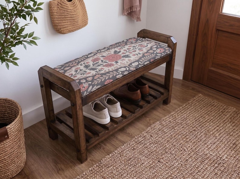 a wooden bench with a floral patterned seat and a shelf underneath, placed in a room with a woven basket and a rug on the floor.