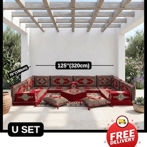 Peut inclure: Un ensemble de sièges en forme de U avec un revêtement rouge et des coussins à motifs. L'ensemble mesure 320 cm de large et 180 cm de profondeur. L'ensemble est présenté sous une pergola en bois.