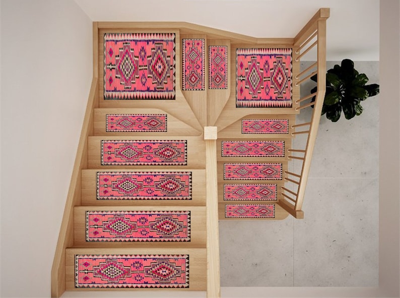 May include: Wooden staircase with pink and black patterned stair treads. The treads feature a geometric design with a central diamond shape and a border of triangles. The risers and landing areas also have matching patterns.
