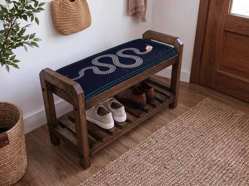 a wooden bench with a blue and white snake design on the seat, placed on a wooden floor next to a woven basket and a rug.