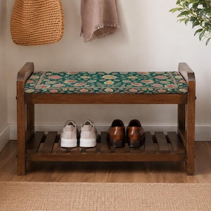 A wooden bench with a green floral patterned seat, displaying a pair of shoes on the lower shelf.