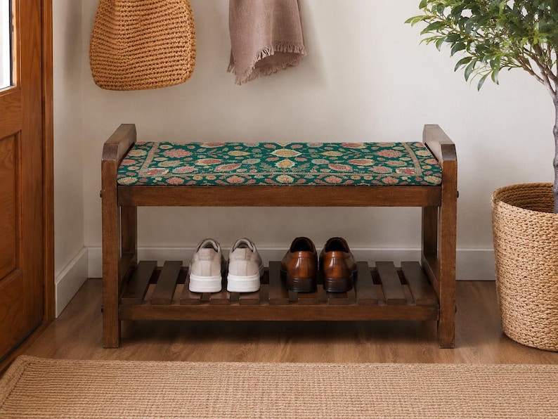 A wooden bench with a green floral patterned seat, displaying a pair of shoes on the lower shelf.