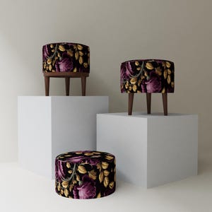 May include: Three decorative ottomans with dark wood legs. The ottomans have a black background with a floral pattern in shades of purple and gold. One ottoman is round and low to the ground, while the other two are taller and have three legs.