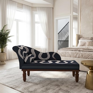 May include: A dark navy blue chaise lounge featuring a repeating white snake pattern with a geometric scale design. The furniture piece has a curved backrest, a matching cylindrical bolster pillow, and four dark brown turned wooden legs.