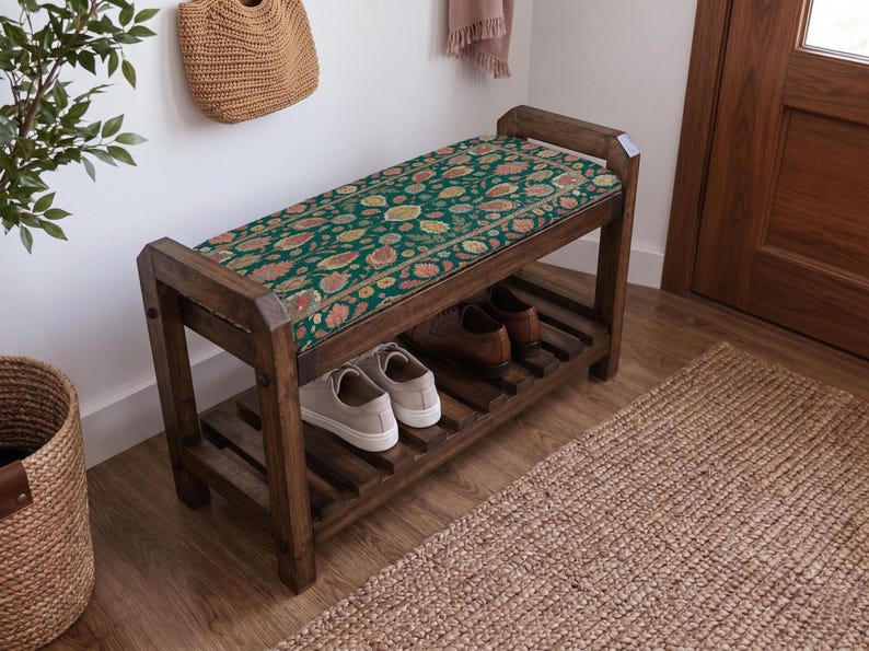 a wooden bench with a colorful floral patterned cushion, placed in a hallway with a woven basket and a rug on the floor.
