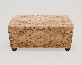 May include: A rectangular storage ottoman with a floral patterned fabric top and bottom. The ottoman has wooden legs.