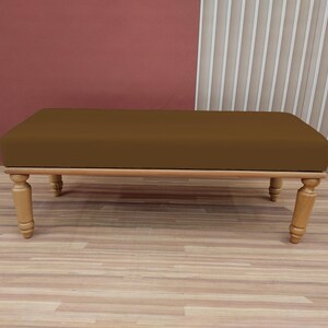 May include: A brown upholstered bench with wooden legs. The bench is sitting on a wooden floor.