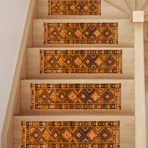 Op de afbeelding: Vijf bruine en zwarte getrapte treden met een geometrisch ontwerp. De treden zijn gerangschikt op een houten trap.