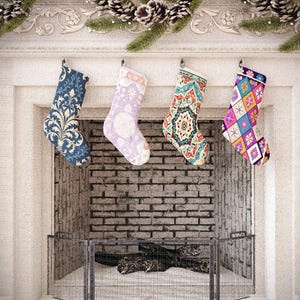 May include: Four Christmas stockings hang above a fireplace. The stockings have various patterns, including floral, geometric, and snowflake designs. The fireplace is white with a brick interior and a metal screen. Pinecones and greenery decorate the mantel.