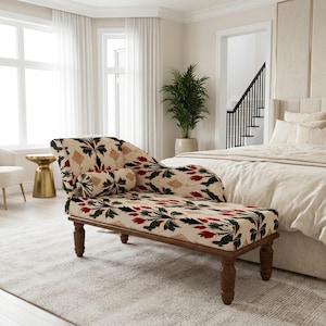 May include: A chaise lounge featuring a cream-colored fabric upholstery with a repeating floral pattern in shades of red, dark green, and tan. The piece is supported by four dark brown wooden legs and includes a matching cylindrical bolster pillow.