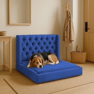 May include: A blue tufted dog bed with a sleeping beagle. The bed has a rectangular base and a tall, button-tufted back. The dog is brown, black, and white. The bed is placed on a woven rug.
