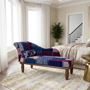 May include: A chaise lounge featuring a patchwork upholstery design in shades of navy blue, deep red, and white with various geometric patterns. The furniture piece is supported by four turned wooden legs and includes a matching cylindrical bolster pillow.