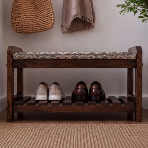 A wooden bench with a woven seat and storage space underneath, displaying a pair of shoes on the lower shelf.