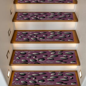 Puede incluir: Peldaños de escalera con fondo morado y un patrón de formas grises y blancas con forma de hojas. Los peldaños están instalados en escaleras de madera con contrahuellas blancas y pequeñas luces empotradas.
