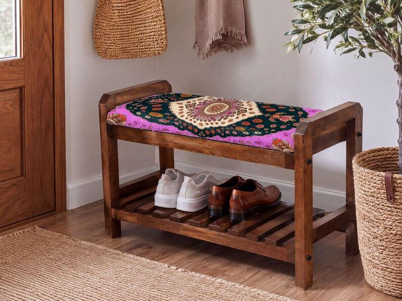 A wooden bench with a colorful patterned seat and a pair of shoes placed on it, situated in a hallway with a woven basket and a potted plant nearby.