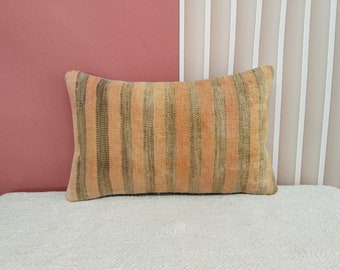May include: A striped throw pillow with a beige and green color scheme. The pillow is made of a soft, textured fabric and has a rectangular shape.