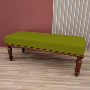 Peut inclure: Un banc en bois avec un siège rembourré vert et des pieds tournés. Le banc est posé sur un sol en bois.