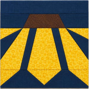 May include: A square fabric quilt block featuring a geometric sunflower design. The center is a brown trapezoid with a speckled texture, surrounded by radiating yellow petals with a subtle circular pattern, all set against a dark blue background.