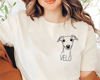 May include: A white t-shirt with a black line drawing of a dog's head and the name "VELO" printed on the front.
