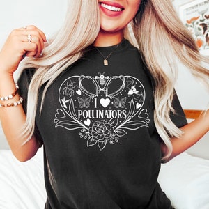 May include: Black t-shirt with a white graphic of a heart with a bee, butterfly, hummingbird, and bat inside. The text "I love pollinators" is written below the heart.