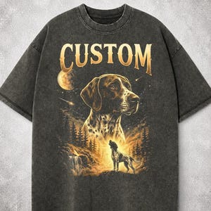 May include: Dark gray t-shirt with a graphic of a dog, a moon, and trees. The word "CUSTOM" is printed in gold letters above the dog's head. The dog is brown and white.