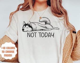 May include: White t-shirt featuring a black and white illustration of a husky dog lying down with the text "NOT TODAY".