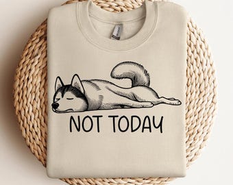 Op de afbeelding: Een beige sweatshirt met een zwart-witte illustratie van een husky die ligt. De tekst "NOT TODAY" staat onder de hond.