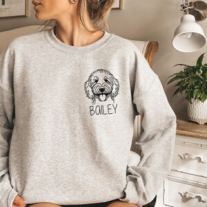 May include: A gray sweatshirt with a black line drawing of a dog's head and the name "BOILEY" printed on the front.