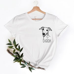May include: White t-shirt with a black and white illustration of a dog's head and the word "DASH" printed below it.