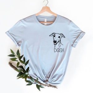 May include: Light blue t-shirt with a black and white illustration of a dog's head and the word "DASH" underneath.