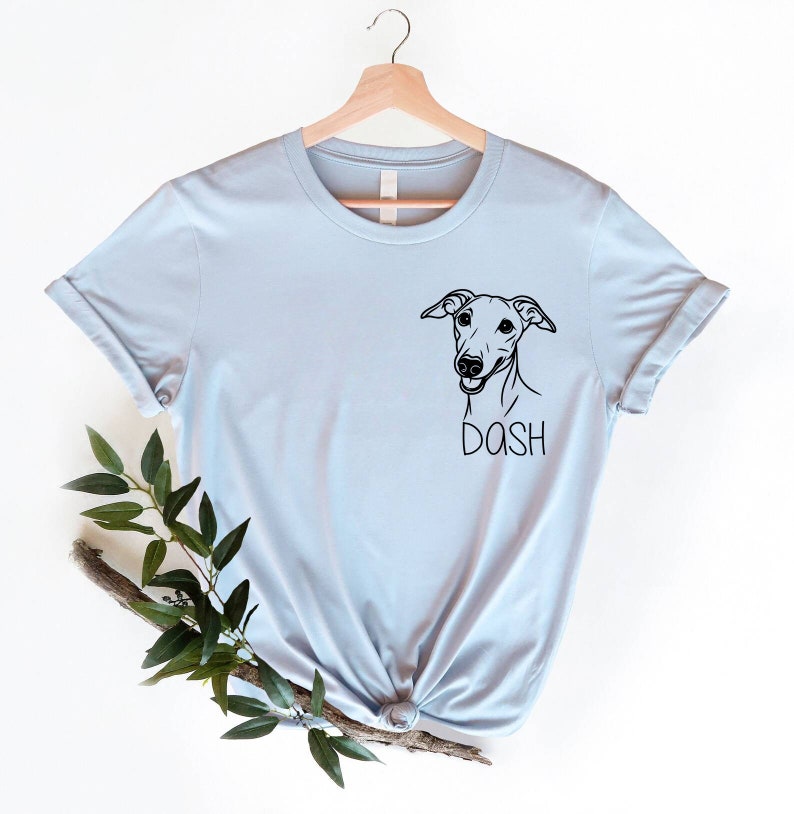 May include: Light blue t-shirt with a black and white illustration of a dog's head and the word "DASH" underneath.