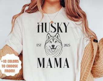 Pode incluir: Camiseta branca com texto preto que diz "Husky Est 2025 Mama" e uma ilustração em preto e branco da cabeça de um husky.